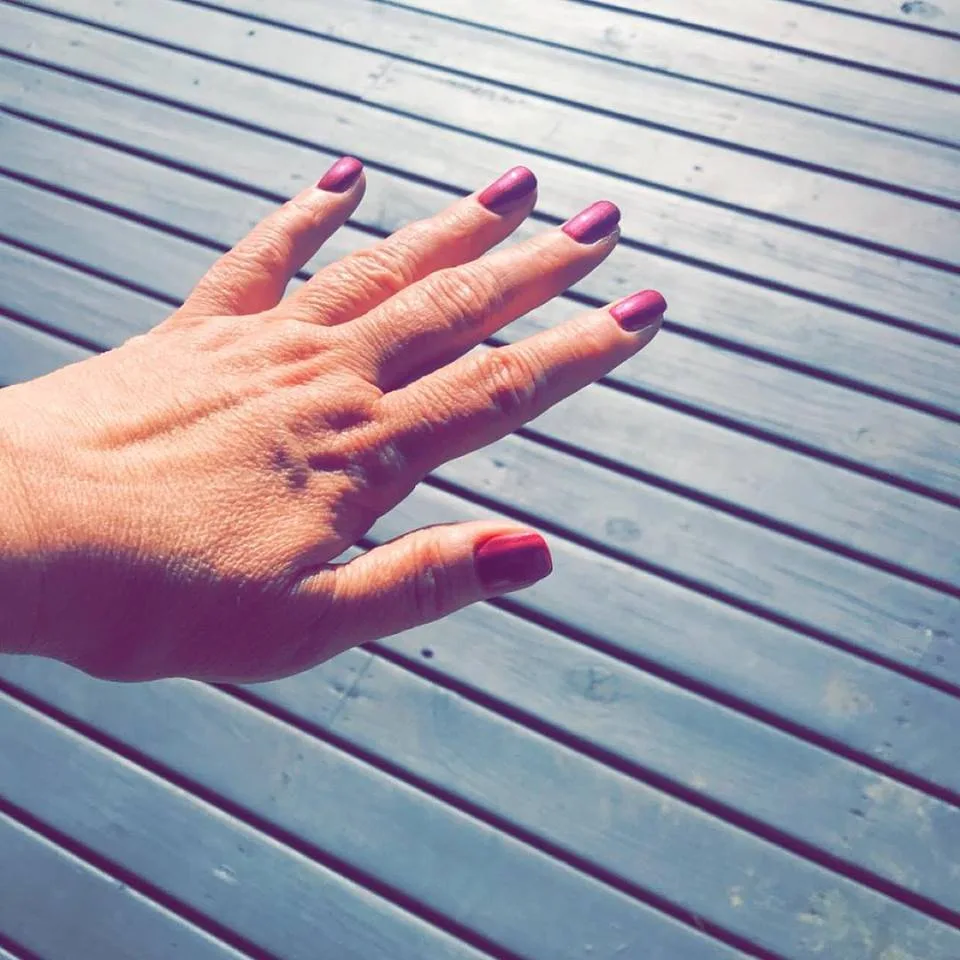 Five nails in a glossy magenta-pink Bio Sculpture gel finish, photographed in natural light